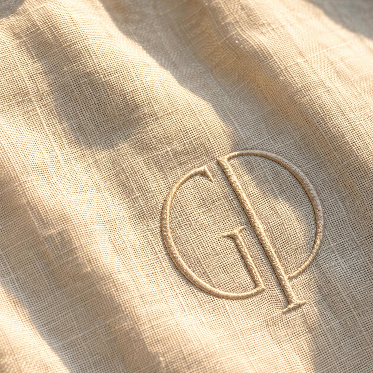 Nahaufnahme des in Gold gestickten GP-Monogramms auf Leinen